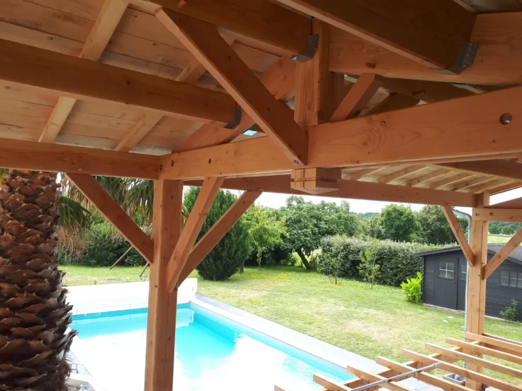 A dark wooden lean-to enhances the front of a pool in Mazeray (17).